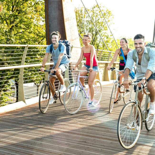 Happy colleagues having fun riding bikes in a city park