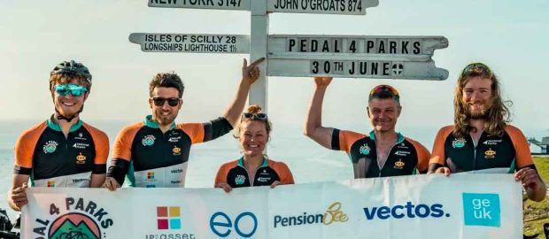 The pedal 4 parks team at land's end with the sponsorship banner.